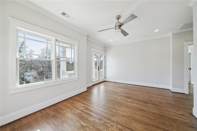 empty room featuring baseboards, wood finished floors, and crown molding