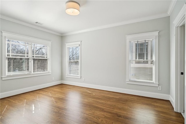 unfurnished room with baseboards, wood finished floors, and crown molding