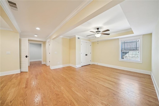 unfurnished room with baseboards, light wood-style floors, visible vents, and ornamental molding