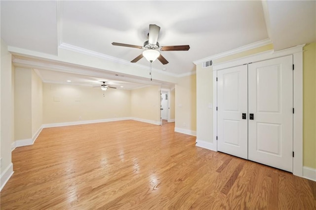 interior space featuring visible vents, light wood-style flooring, crown molding, baseboards, and ceiling fan