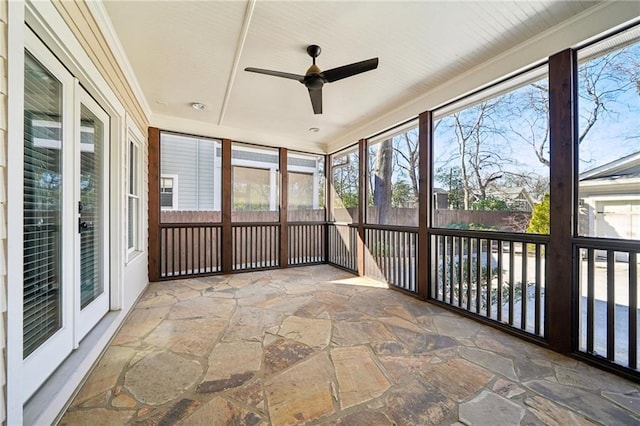 unfurnished sunroom featuring ceiling fan