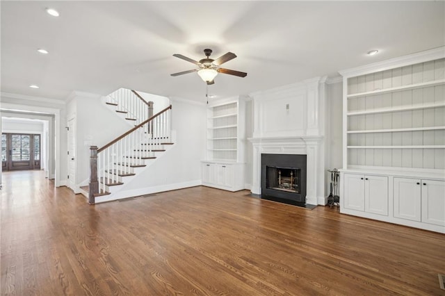 unfurnished living room featuring ornamental molding, stairway, a fireplace, baseboards, and dark wood-style flooring