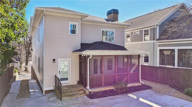 rear view of house featuring a sunroom, central AC, a chimney, and fence