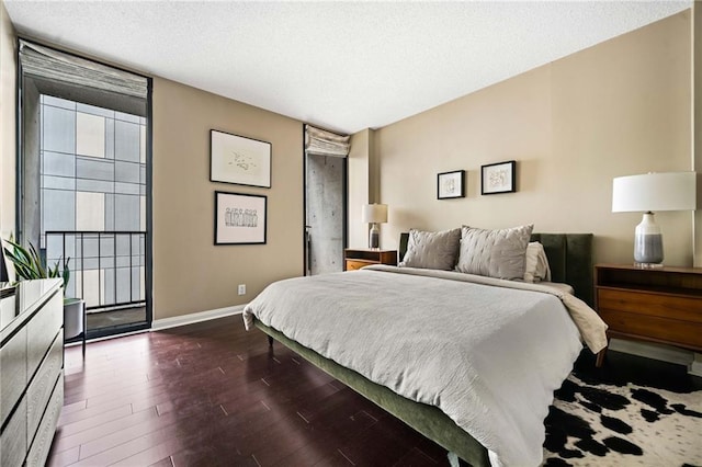 145 15th St NE Unit 435, Atlanta, GA 30309 - bedroom with baseboards, dark wood-style flooring, and a textured ceiling