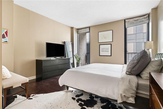 145 15th St NE Unit 435, Atlanta, GA 30309 - bedroom with wood finished floors, baseboards, and a textured ceiling