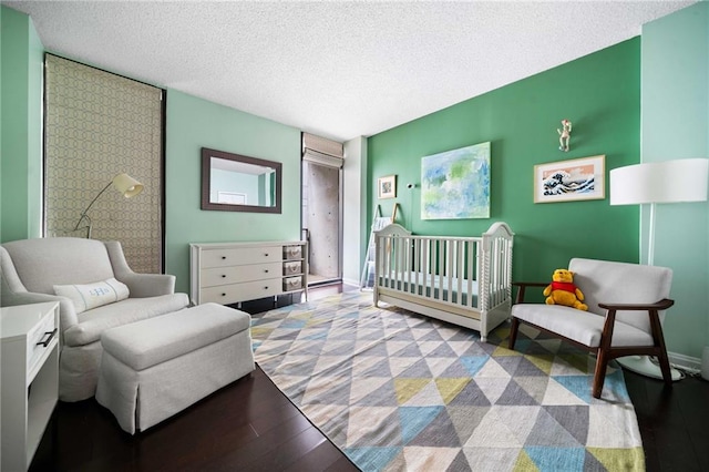 145 15th St NE Unit 435, Atlanta, GA 30309 - bedroom with wood finished floors, a textured ceiling, and a crib