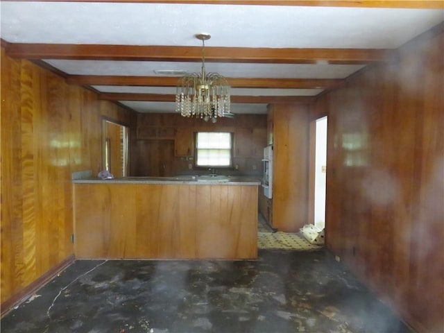 2447 Omaha Rd SW, Atlanta, GA 30331 - kitchen featuring a peninsula, a chandelier, wood walls, beamed ceiling, and brown cabinets