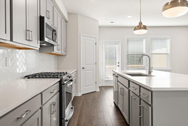 kitchen featuring pendant lighting, appliances with stainless steel finishes, sink, plenty of natural light, and gray cabinets