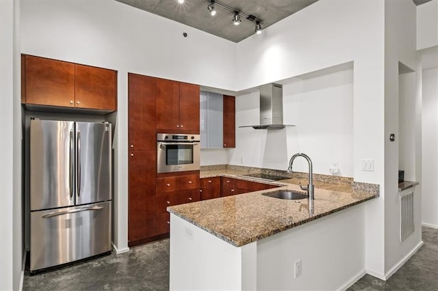 kitchen featuring appliances with stainless steel finishes, sink, kitchen peninsula, light stone countertops, and wall chimney exhaust hood