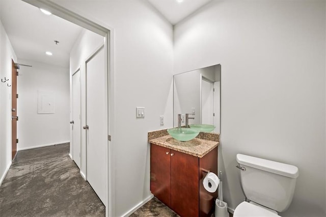 bathroom featuring vanity, concrete floors, and toilet