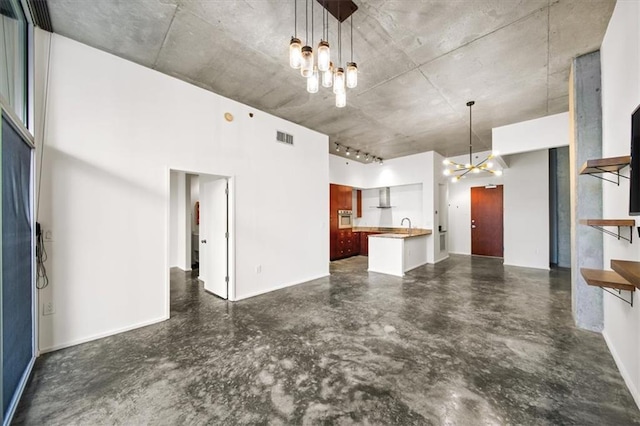 unfurnished living room with a notable chandelier and a high ceiling