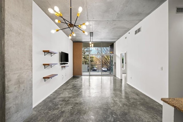 unfurnished living room featuring floor to ceiling windows, concrete flooring, and a notable chandelier