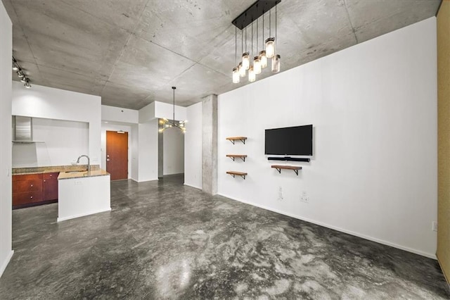 unfurnished living room with sink and a notable chandelier