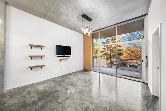 unfurnished living room featuring a wall of windows, a chandelier, and concrete floors