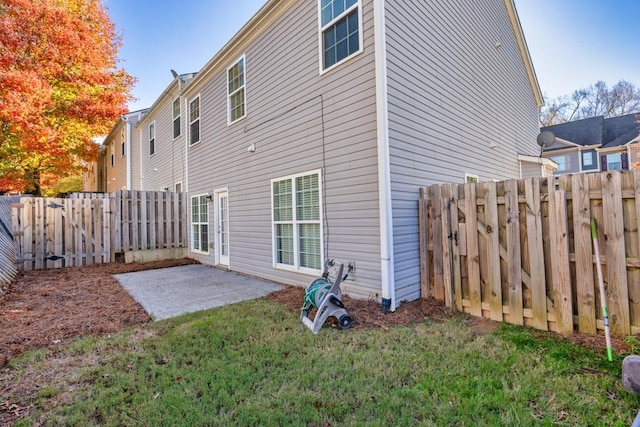 rear view of house featuring a patio and a lawn