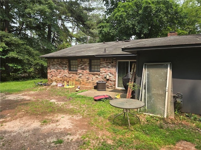 1203 Balboa Ct, Norcross, GA 30093 - back of house featuring brick siding, central air condition unit, a chimney, and a shingled roof