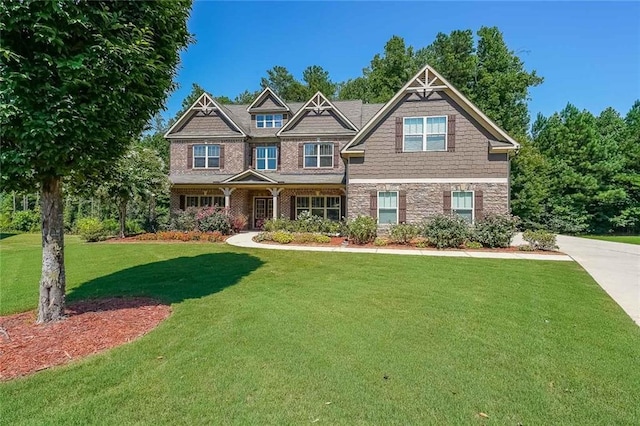 craftsman-style house with a front yard and stone siding