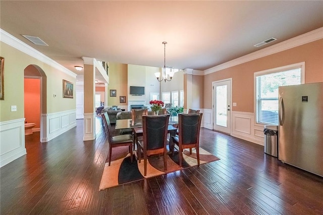 dining room featuring crown molding, dark hardwood / wood-style flooring, and a chandelier