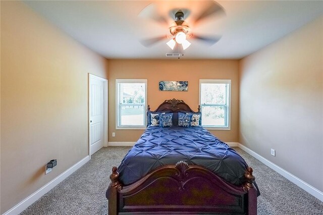 carpeted bedroom with ceiling fan and multiple windows