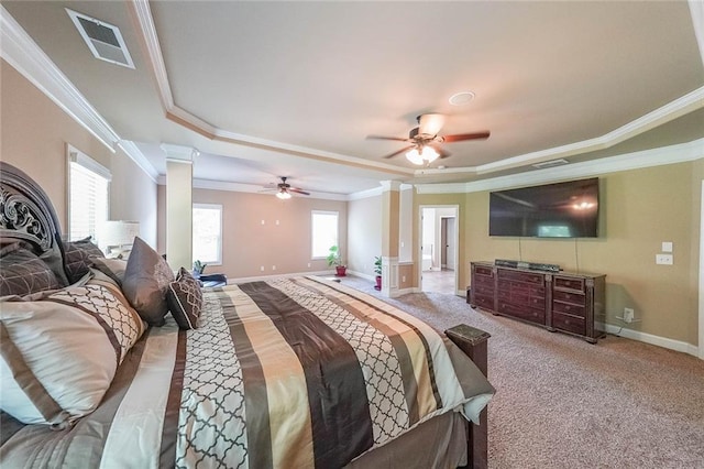 bedroom with a raised ceiling, ornamental molding, decorative columns, and carpet floors