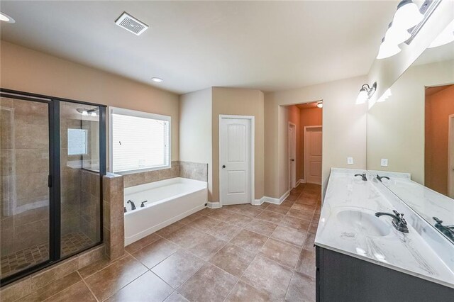 bathroom with tile patterned floors, shower with separate bathtub, and double sink vanity