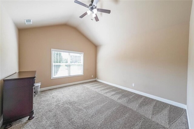 empty room featuring lofted ceiling, carpet, and ceiling fan