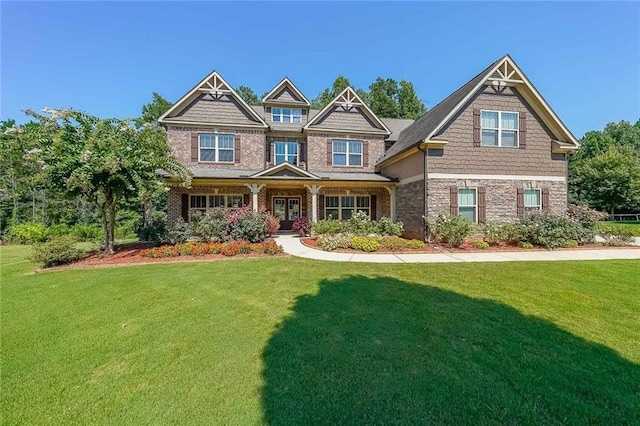 craftsman inspired home featuring a front yard and stone siding