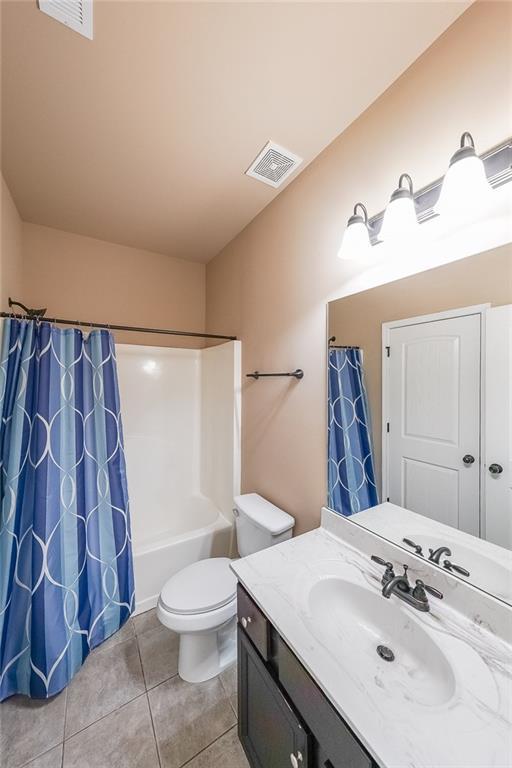 full bathroom featuring vanity, tile patterned flooring, shower / bath combination with curtain, and toilet