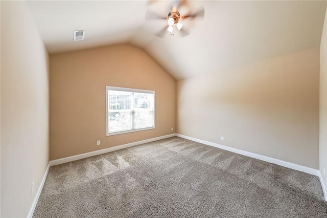 spare room featuring ceiling fan, vaulted ceiling, and carpet