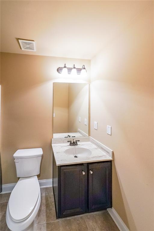 bathroom featuring tile patterned floors, vanity, and toilet