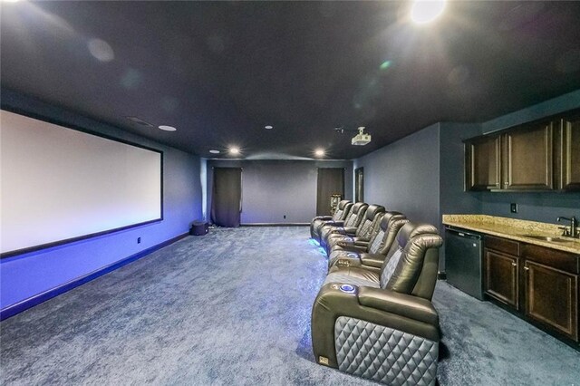 cinema room with sink and light colored carpet