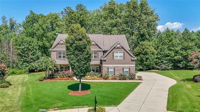 craftsman house with concrete driveway and a front yard