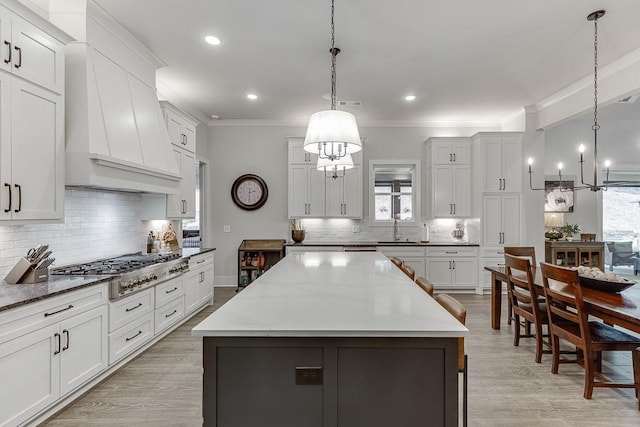 1889 Jefferson River Rd, Jefferson, GA 30549 - kitchen with stainless steel gas stovetop, premium range hood, decorative backsplash, a chandelier, and healthy amount of natural light