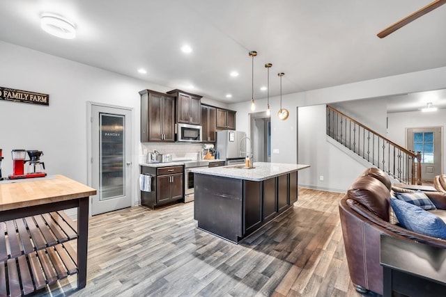 386 Summersong Pl, Talmo, GA 30575 - kitchen with stainless steel microwave, wine cooler, light wood-style flooring, open floor plan, and dark brown cabinets