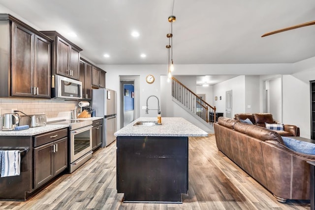 386 Summersong Pl, Talmo, GA 30575 - kitchen featuring appliances with stainless steel finishes, open floor plan, dark brown cabinets, and recessed lighting