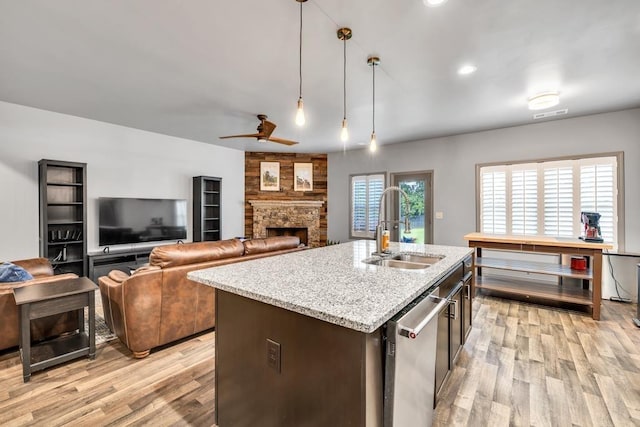 386 Summersong Pl, Talmo, GA 30575 - kitchen featuring light wood finished floors, a stone fireplace, light stone countertops, dishwasher, and pendant lighting
