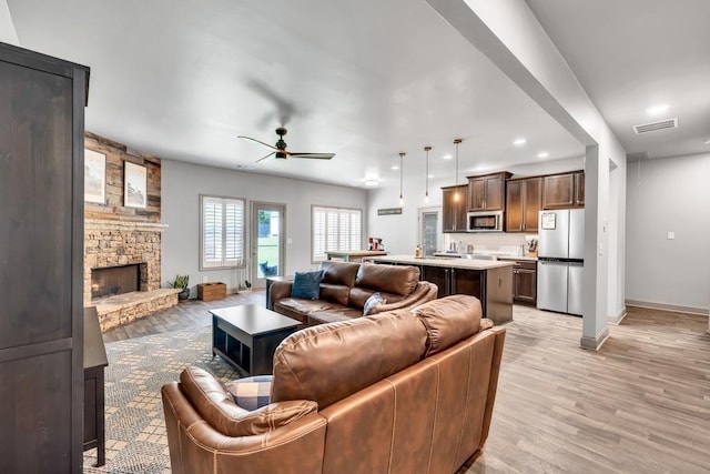 386 Summersong Pl, Talmo, GA 30575 - living area featuring a stone fireplace, ceiling fan, light wood-type flooring, and recessed lighting