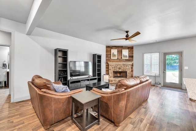 386 Summersong Pl, Talmo, GA 30575 - living room featuring ceiling fan, a stone fireplace, light wood-style floors, and beamed ceiling