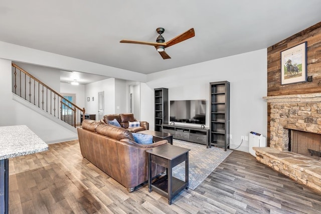 386 Summersong Pl, Talmo, GA 30575 - living room featuring ceiling fan, stairway, wood finished floors, and a stone fireplace