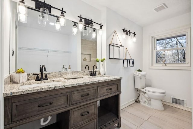 7994 Devonshire Dr, Jonesboro, GA 30238 - bathroom with double vanity, baseboards, toilet, a walk in closet, and a shower