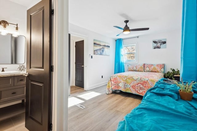 7994 Devonshire Dr, Jonesboro, GA 30238 - bedroom with light wood-type flooring, baseboards, a ceiling fan, and a sink