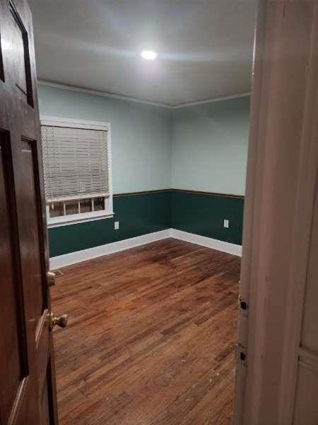 empty room with baseboards and wood finished floors