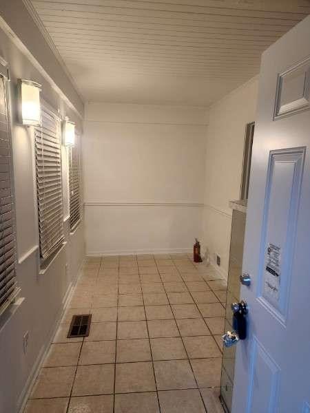 interior space with light tile patterned floors, visible vents, and wood ceiling