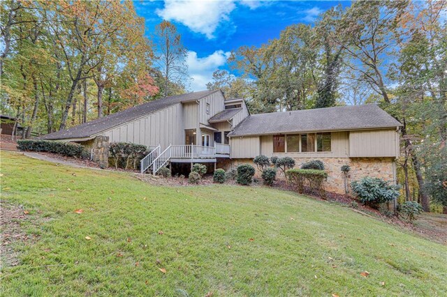 view of front of home with a front lawn and a wooden deck