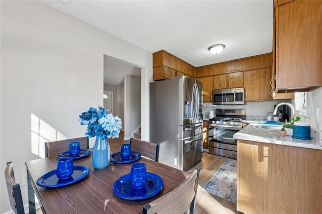 kitchen featuring sink, light hardwood / wood-style floors, and appliances with stainless steel finishes