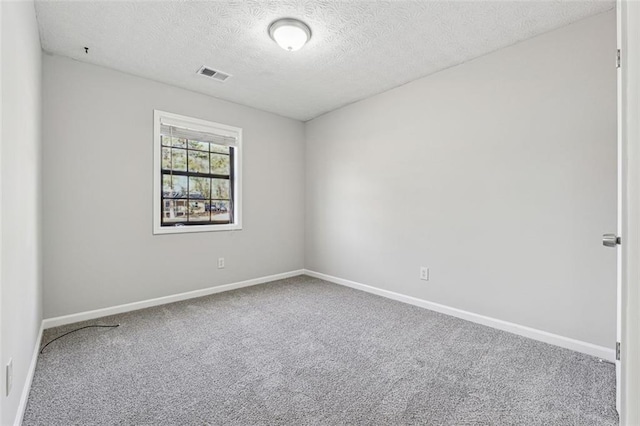 carpeted spare room featuring a textured ceiling