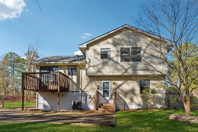 back of house featuring a wooden deck, cooling unit, and a lawn