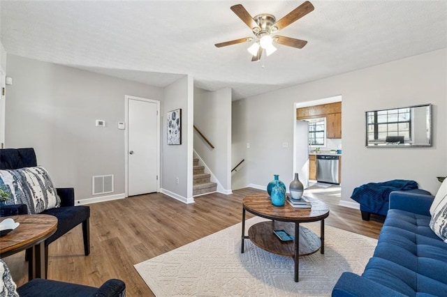 living room featuring wood-type flooring and ceiling fan