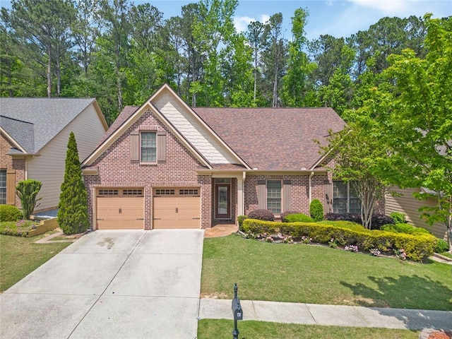 view of front facade with a shingled roof, driveway, a front lawn, and brick siding