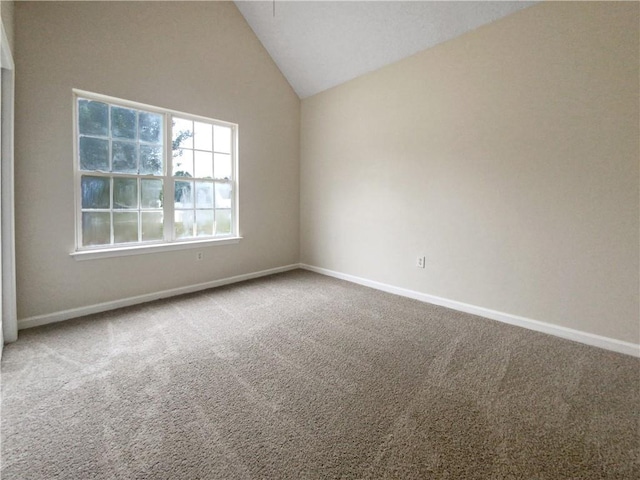 carpeted spare room featuring vaulted ceiling